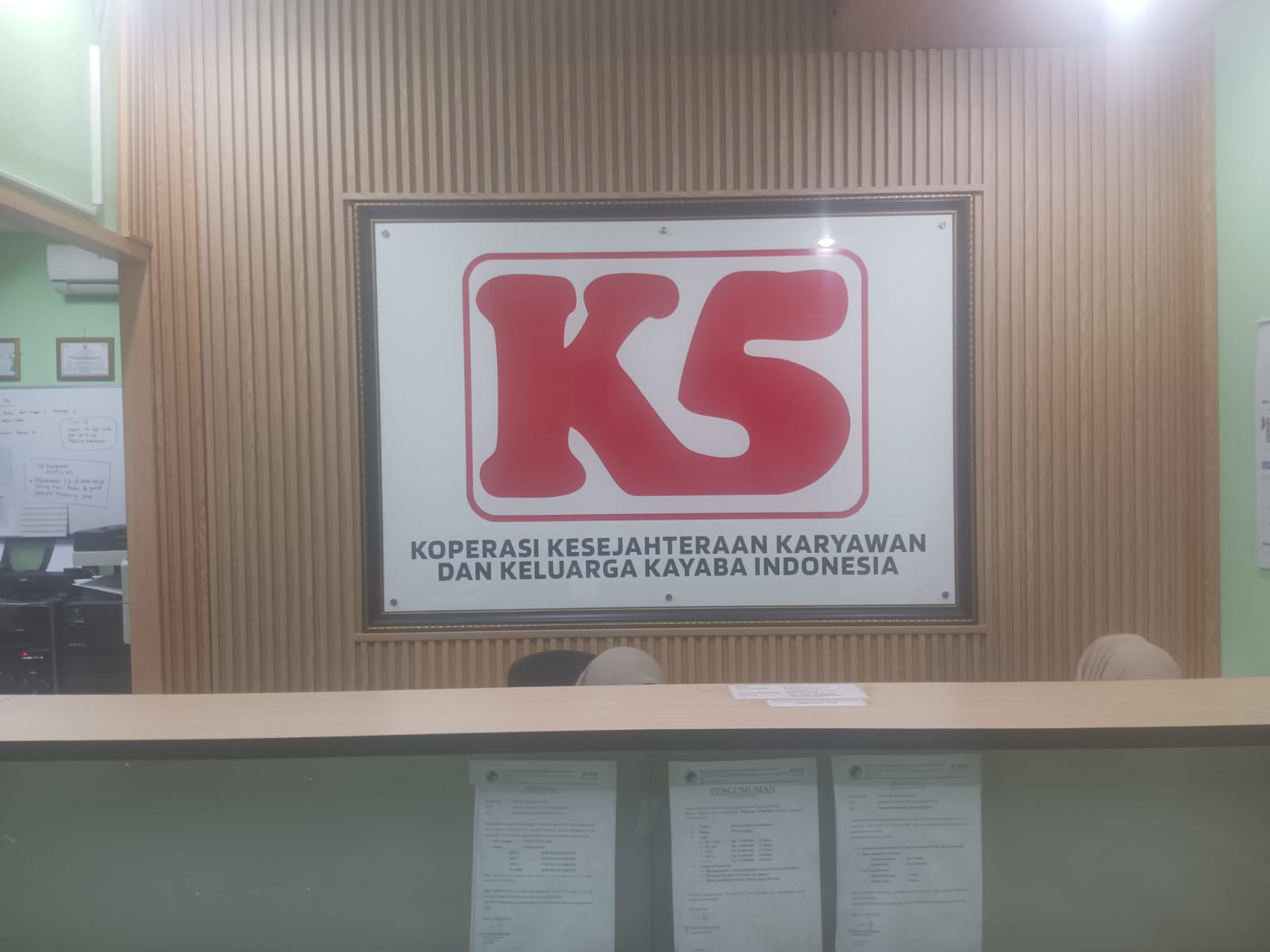 Meja pelayanan dan papan identitas K5 di kantor Koperasi Kayaba